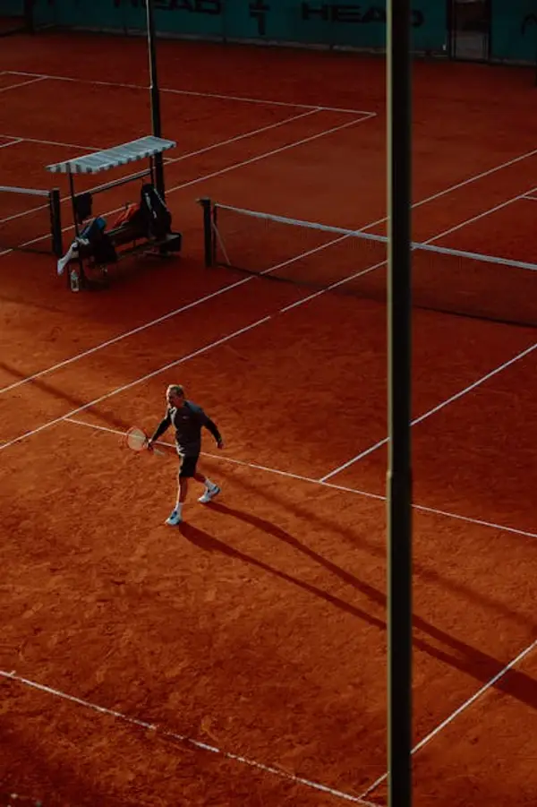 En mann som spiller tennis på en bane