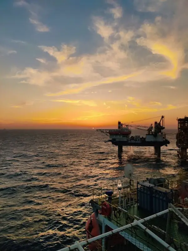 Oljerigg plattform ved solnedgang over havet