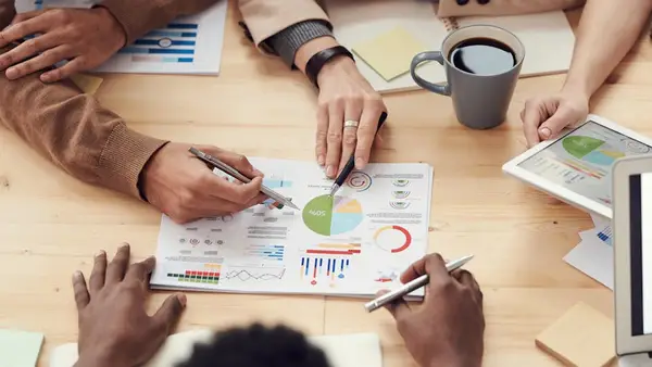 folk som diskuterer finansielle diagrammer