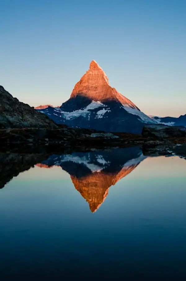 Solnedgang over fjell og innsjø