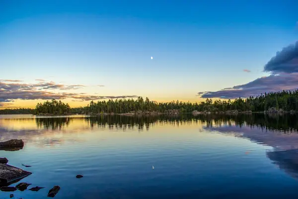 solnedgang speilet på innsjøen