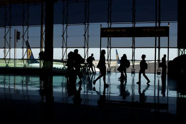 reisende som går gjennom flyplassens terminal